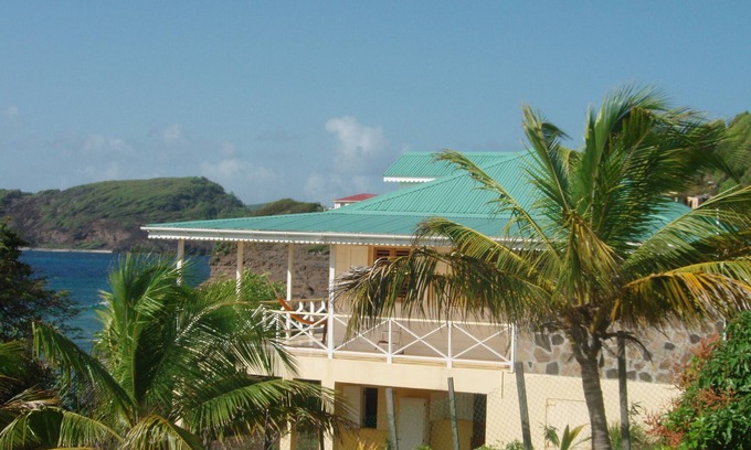 Friendship House | Charming seaside villa with wraparound veranda, ocean views and wind.