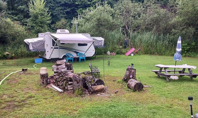 Forestville RV Rental | Comfortable Camper a few miles off thruway and area attractions. Fire ring wood