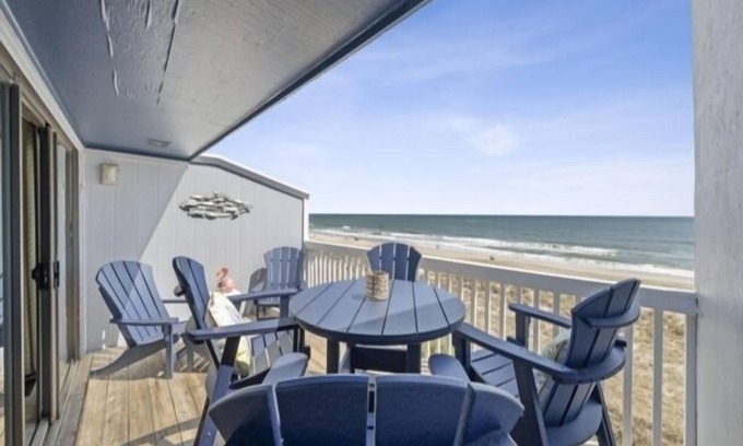Wilmington Beach Condo | Conched Out - Feel the ocean breezes as you relax on the deck overlooking the lovely Carolina Beach coastline by RedAwning