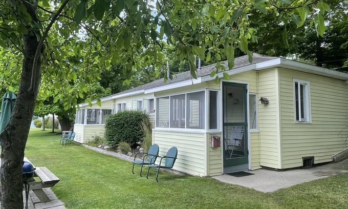 Ludington Cottage | Cottage 1 is a charming 2 bedroom only 25’ from its boat dock & Hamlin lake.