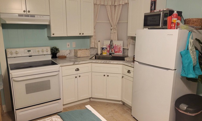 Goldenrod House | Cozy XL room with kitchenette, dining table, couch, and smart tv, shared bath