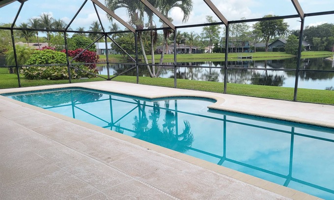 Wellington House | Golf cart distance to WEF! Charming 3 bedroom waterfront home with heated pool.
