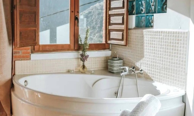 Santa Maria Apartment | Jacuzzi in bedroom with mountain views and fireplace