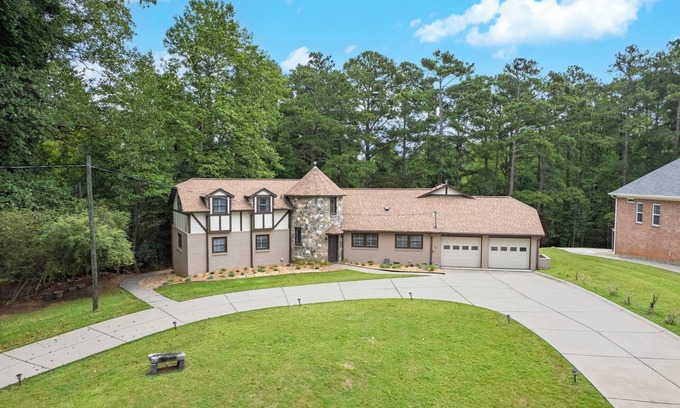 Flowery Branch House | Lakefront 4BR/6BA home with private dock, fire pit, smart TVs in all rooms, sunroom, BBQ grill, and fenced game yard. Includes golf cart, 2 fridges, double oven, and more. 1 mile to Aqualand Marina & Pig Tales Restaurant.