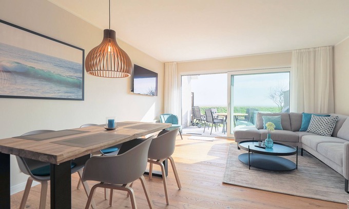 Rantum House | The walls are painted in a warm beige and decorated with cool pictures.