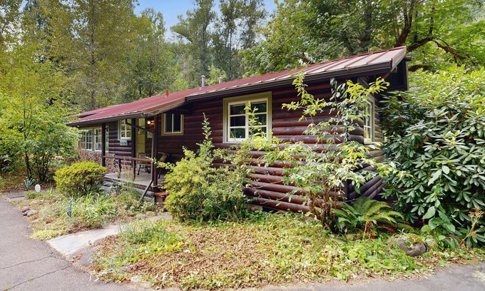 Molalla Cottage | Tranquil landscape with riverside firepit, gas grill, gas fireplace, and deck