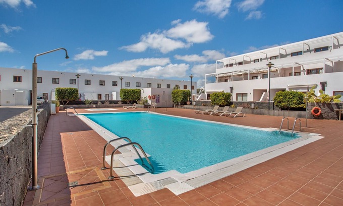 Costa Teguise Apartment | Vacation 'Queen Ovetus Planta Baja' with Mountain View, Shared Pool and Wi-Fi