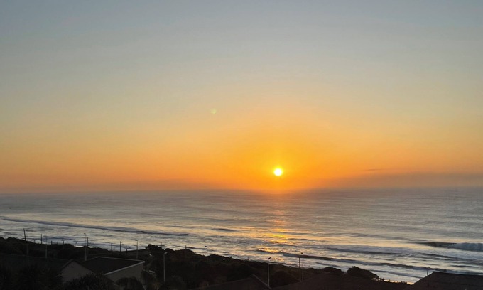 Warner Beach Cottage | Wake up to gorgeous sunrises and sea views upon a wooden balcony.
