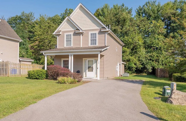 Spacious family home with multiple bedrooms, full kitchen, porch, and quaint backyard.