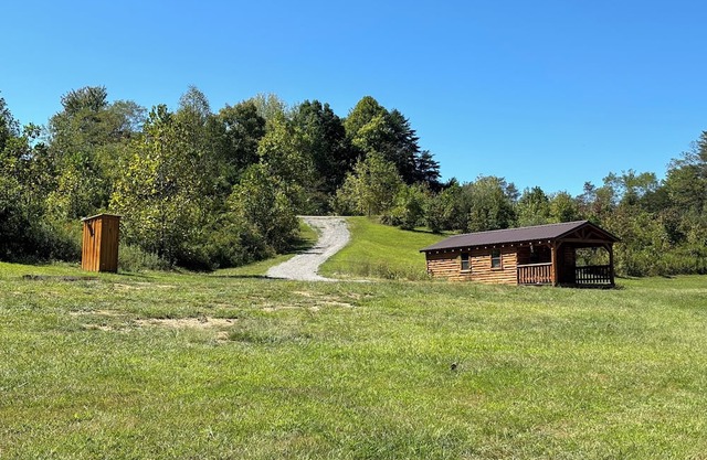 Charming one-room cabin retreat with private bath, kitchenette and log gazebo.